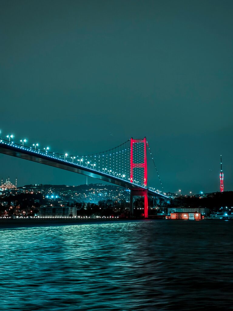 Experience the illuminated beauty of Istanbul's Bosphorus Bridge at night, spanning the vibrant cityscape.