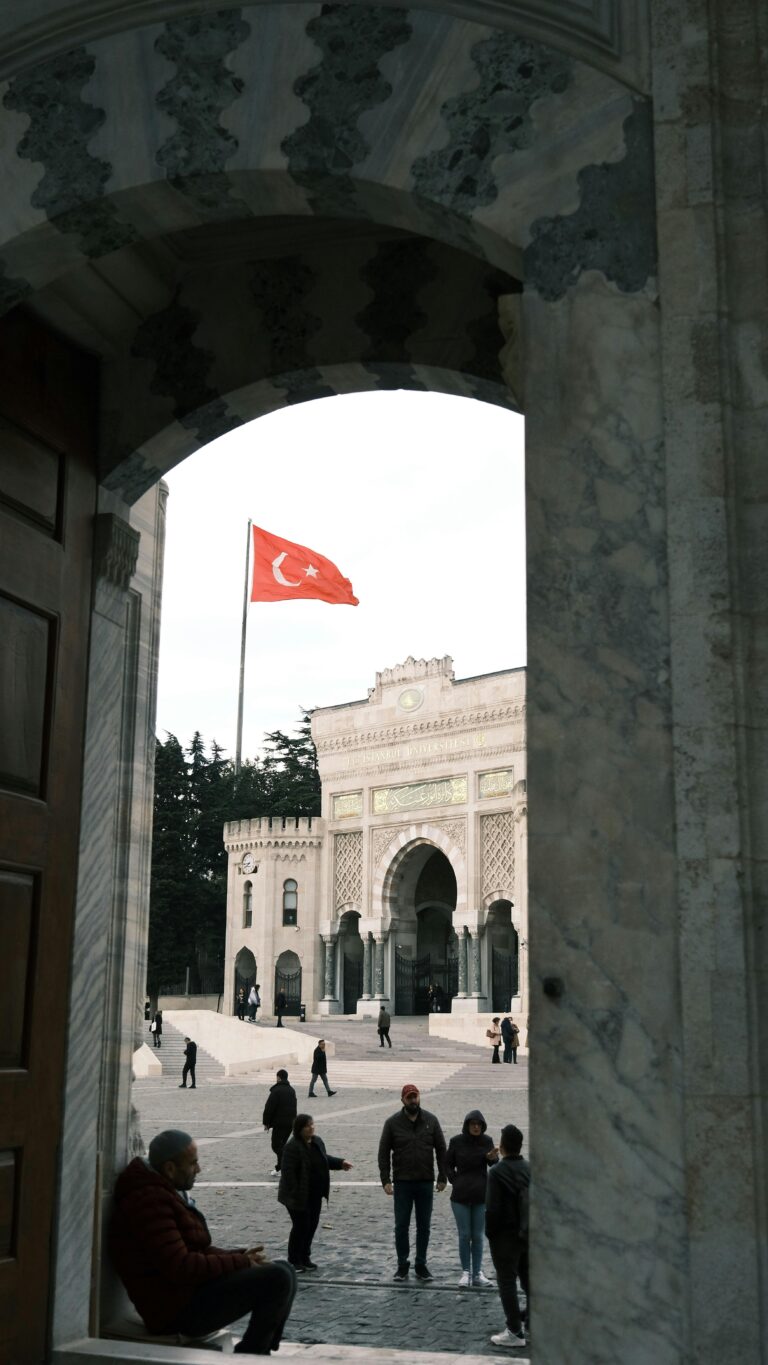 View of Istanbul University's main entrance with Turkish flag flying.